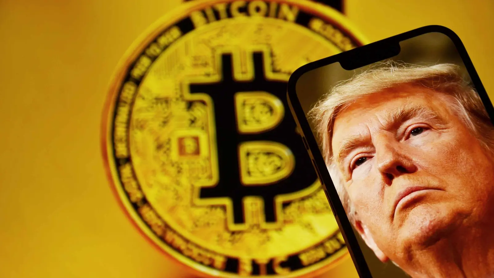 الرئيس الأميركي دونالد ترامب يظهر على شاشة هاتف ذكي، وخلفه شعار عملة «بيتكوين»